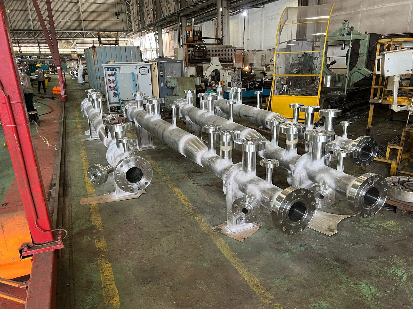 Stainless steel header with multiple branch outlets and flanged connections in the fabrication shop